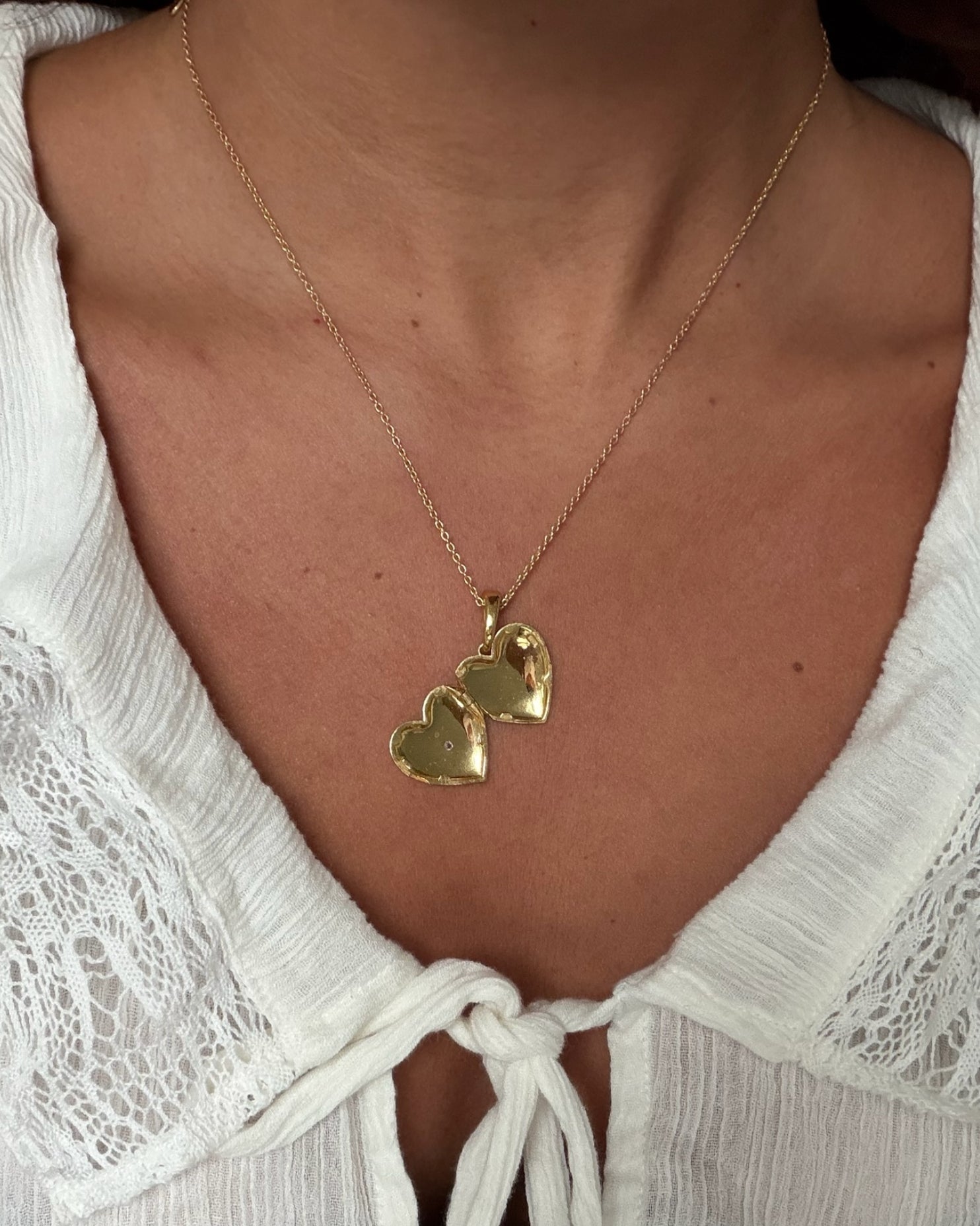 Gold heart locket necklace on delicate chain