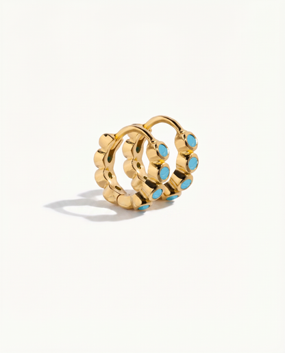 Gold hoop earrings with turquoise stones on a white background